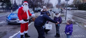 Mikołaj, policjantka i dzieci przy radiowozie