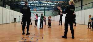 Uczniowie klasy policyjnej i dzieci na hali sportowej