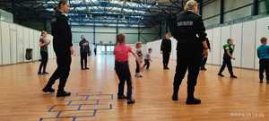 Uczniowie klasy policyjnej i dzieci na hali sportowej