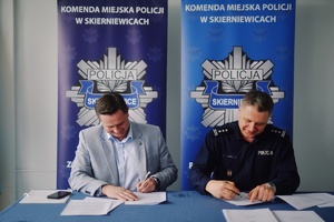 Prezydent Miasta i Komendant Miejski Policji przy biurku w trakcie podpisywania dokumentów