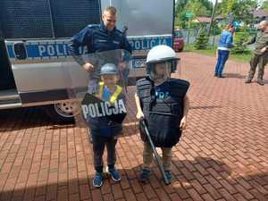 Policjant i dwoje dzieci przed radiowozem