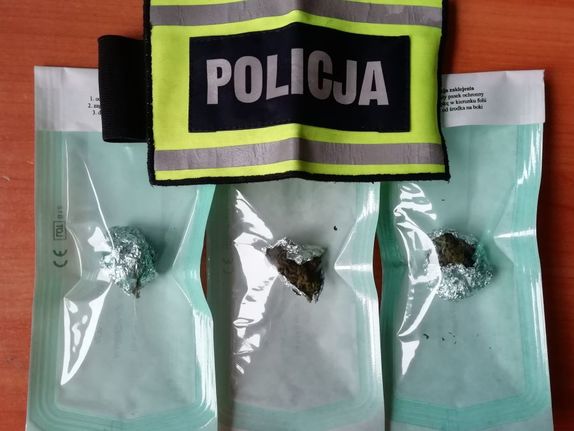 Trzy kulki folii aluminiowej w pakietach papierowo-foliowych i napis policja