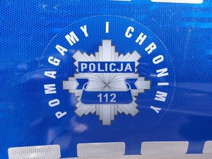 Odznaka policyjna i napis pomagamy i chronimy