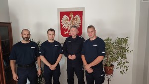 Czterej mężczyźni w mundurach policyjnych -komendant i nowoprzyjęci rekruci.