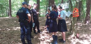 Policjanci, strażacy i uczestnicy obozu podczas spotkania w lesie