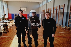 Młodzież z klasy mundurowej przymierzająca policyjny strój.