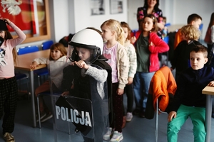 Dzieci przymierzające ubrania policyjne.