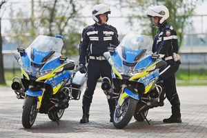 Policjanci przy motocyklach służbowych.