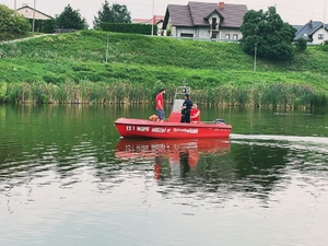 Policjantka wraz ze strażakami na łódce podczas patrolu zalewu.