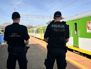 Policjant wraz ze Strażnikiem Ochrony Kolei na stacji kolejowej podczas patrolu.