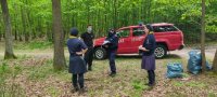 Policjantka  w lesie, obok dwie harcerki, na tle samochodu straży pożarnej