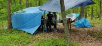 Policjantka  w lesie stoi pod namiotem