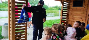 Policjantka i dzieci siedzące w altanie nad zalewem