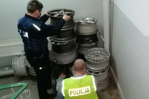 policjanci zabezpieczają odzyskane felgi aluminiowe