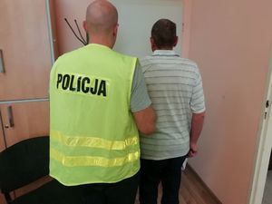 Mężczyzna i policjant w żółtej kamizelce z napisem policja w pokoju służbowym