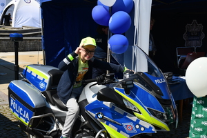 Chłopczyk siedzi na policyjnym motocyklu służbowym.