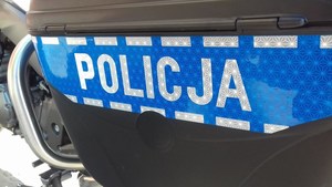czarny bak motocykla policyjnego, po środku niebieski pas z szarym napisem Policja