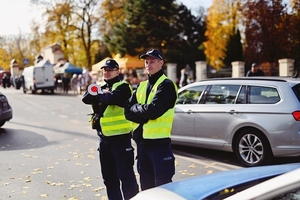 Policjanci kierujący ruchem przy cmentarzu.