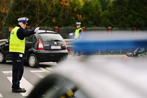 Policjant w mundurze na ulicy kierujący ruchem.