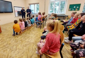 Policjanci prowadzący spotkanie profilaktyczne w klasie z grupą dzieci.