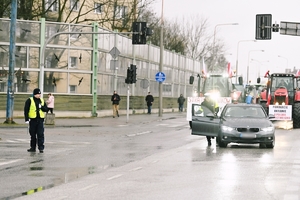 Przejazd rolników przez skrzyżowanie, policjanci kierują ruchem.