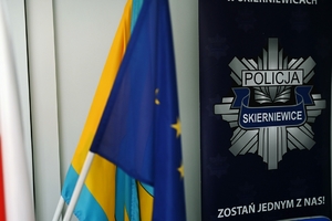 Logo policji wraz z flagą miasta Skierniewice.