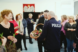 Prezydent wręczający kwiaty kobietom pracującym w Komendzie Miejskiej Policji w Skierniewicach.