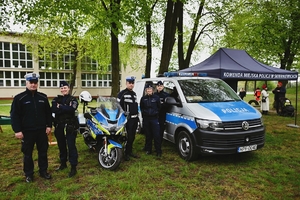 Zdjęcie grupowe policjantów przy radiowozie i motocyklu.
