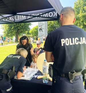 Policjanci na stanowisku rozłożonym na pikniku rodzinnym.