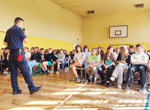 Policjant z młodzieżą podczas prelekcji.