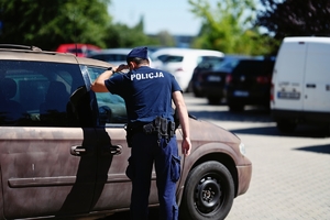 Policjant sprawdzający czy w środku auta nie znajdują się dzieci lub zwierzęta.