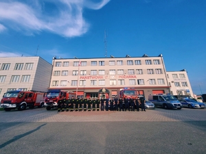 Policjanci wraz ze strażakami przy budynku Państwowej Straży Pożarnej oddający hołd poległym strażakom.