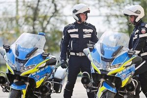 Policjanci ruchu drogowego przy policyjnych motocyklach.