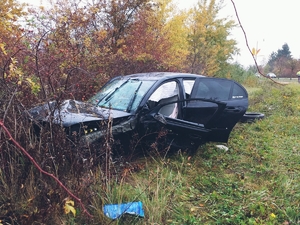 Auto z uszkodzeniami po kolizyjnymi, które zatrzymało się na przydrożnych drzewach.