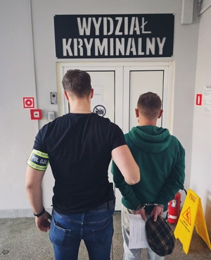 Policjant Kryminalny z zatrzymanym podczas doprowadzenia.