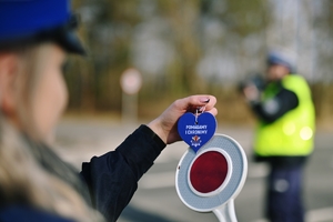 Policjantka trzymająca w dłoni serduszko jak kocha to poczeka.