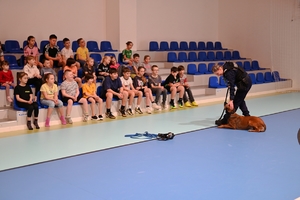 Policjantka wraz z psem służbowym podczas spotkania z dziećmi.