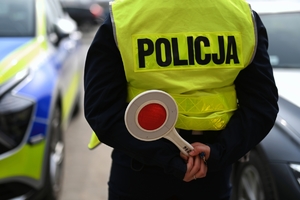 Policjant ruchu drogowego trzymający w dłoni tarczę do zatrzymywania.