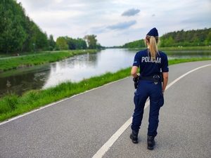 Policjantka w patrolu pieszym nad zalewem zadębie.