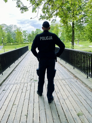 Policjant w parku miejskim w patrolu pieszym.
