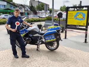 Policjant stojący przy motocyklu.