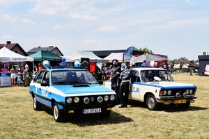 Policjanci przy zabytkowych radiowozach.