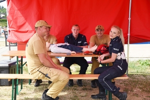 Policjanci i strażacy wspólnie pod namiotem.
