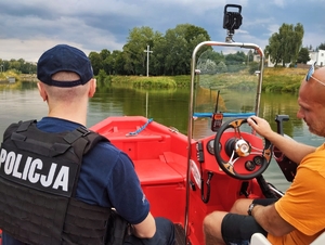 Policjant patrolujący akwen z łodzi.