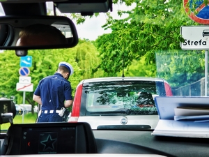 Policjant ruchu drogowego podczas kontroli pojazdu.