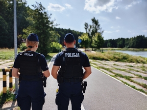Policjanci podczas patrolu pieszego na ścieżce pieszo-rowerowej.