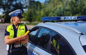 Policjantka ruchu drogowego przy radiowozie.