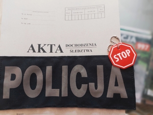 Napis policja na tle teczki akt sprawy.
