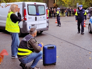 Technik kryminalistyczny i policjant śledczy działający na miejscu zdarzenia.
