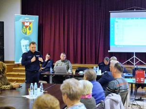 Komendant Miejski Policji w Skierniewicach podczas debaty z seniorami o zagrożeniach.